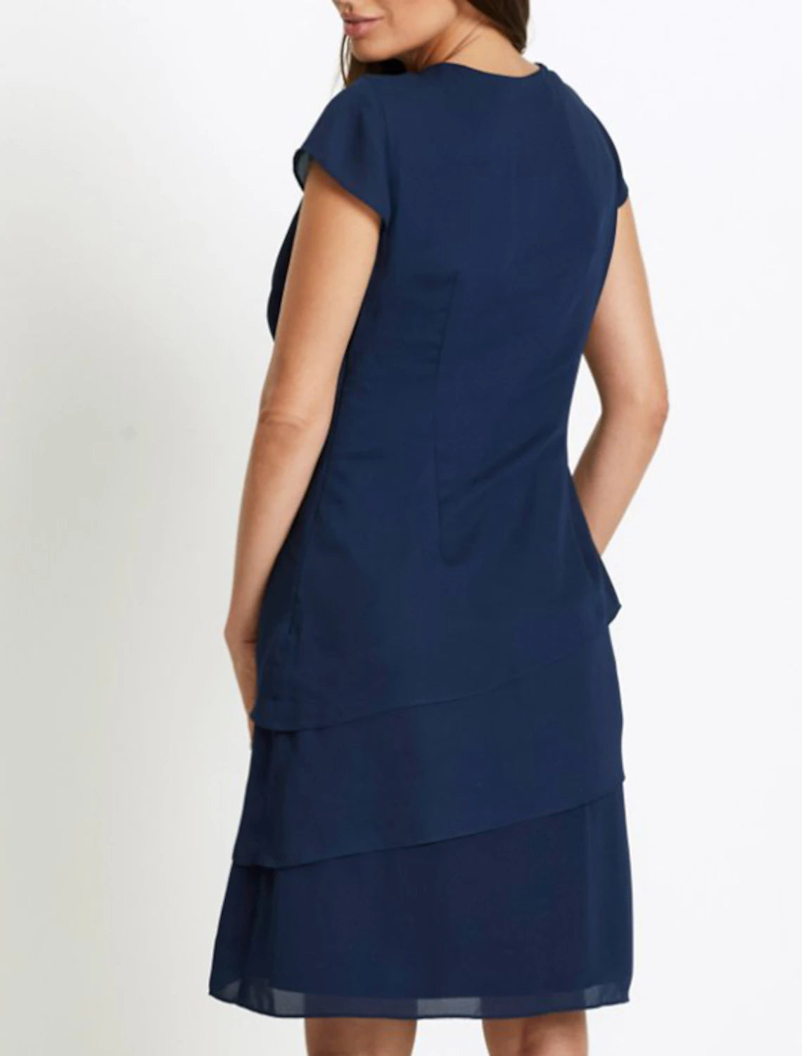 Woman wearing an elegant navy blue short sleeve ruched midi shift dress, side view.