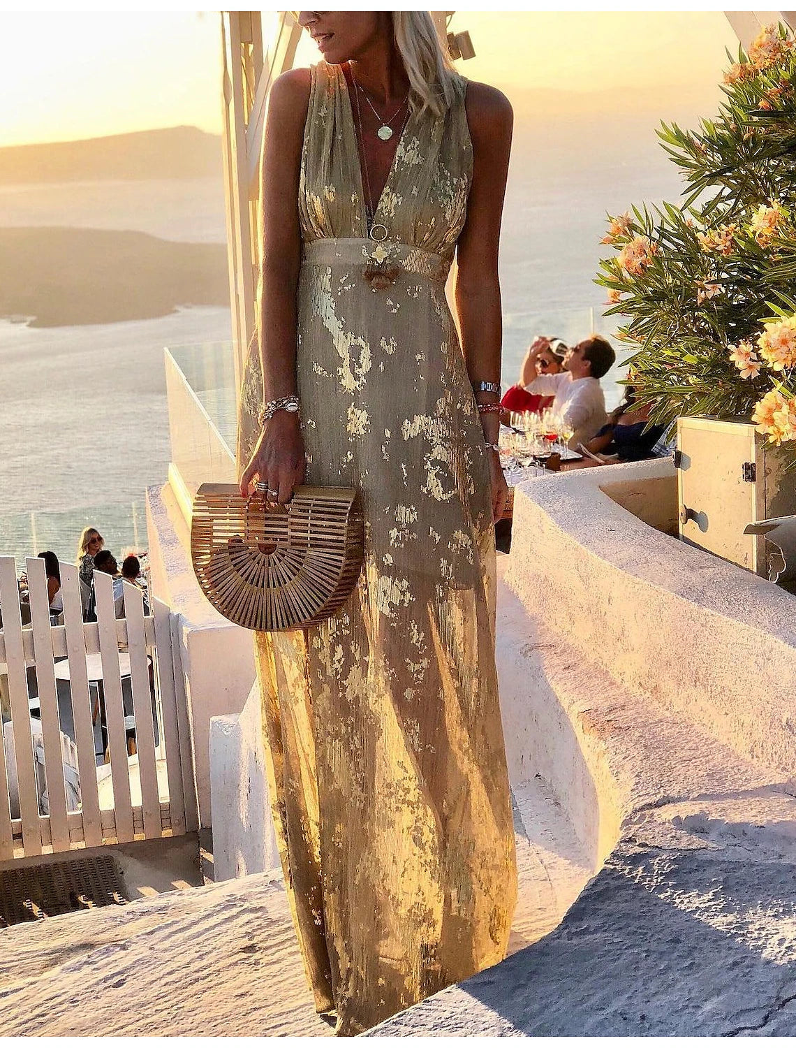 Woman wearing an elegant shimmering A-line deep V sleeveless party dress.