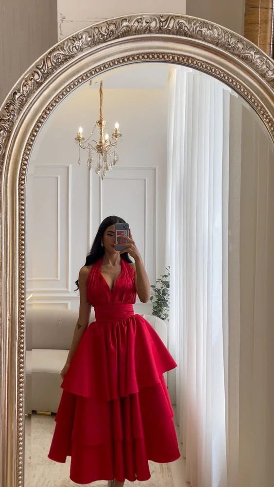 Woman posing in an elegant short satin halter plunge V evening dress.