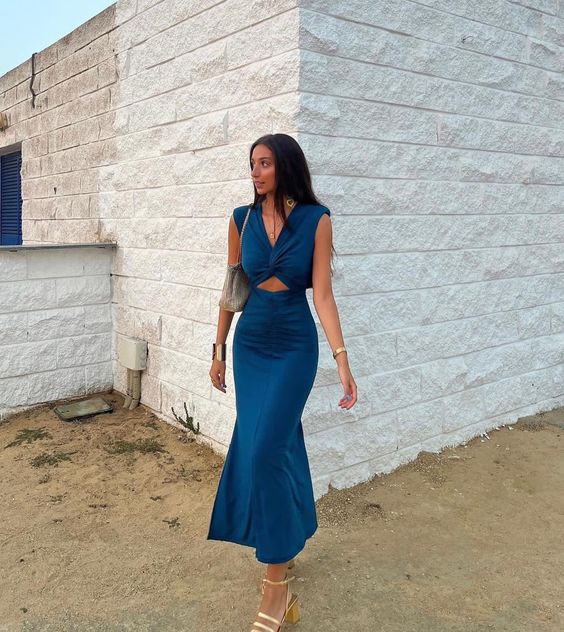 Elegant woman in a long navy blue sleeveless mermaid evening dress.