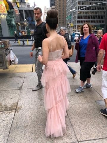Close-up of the light pink fabric and design details of the dress.