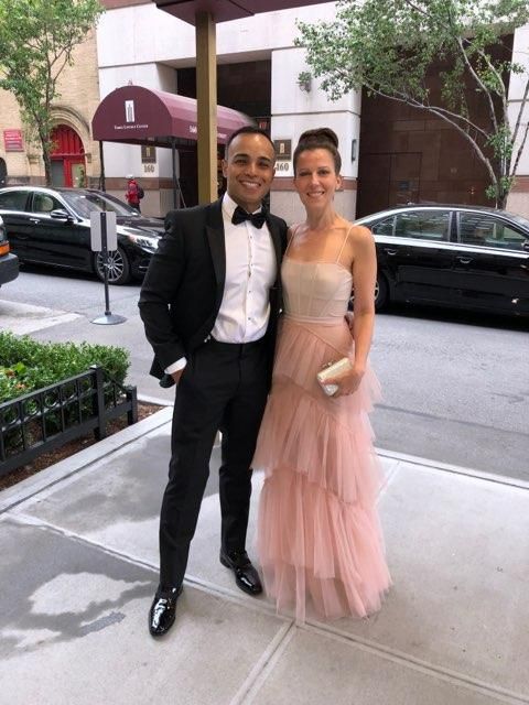 Woman posing gracefully in a light pink long party dress.