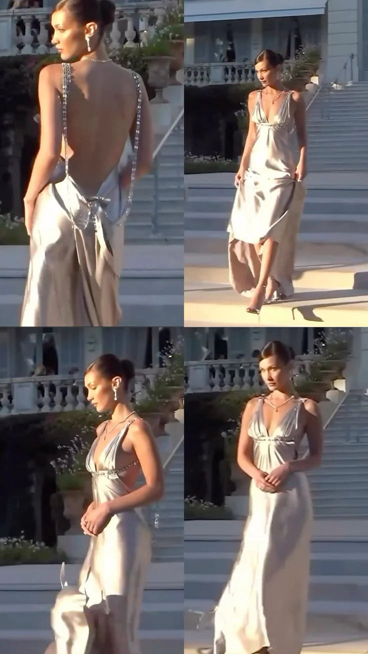 Full length view of a woman posing in a black backless evening dress.