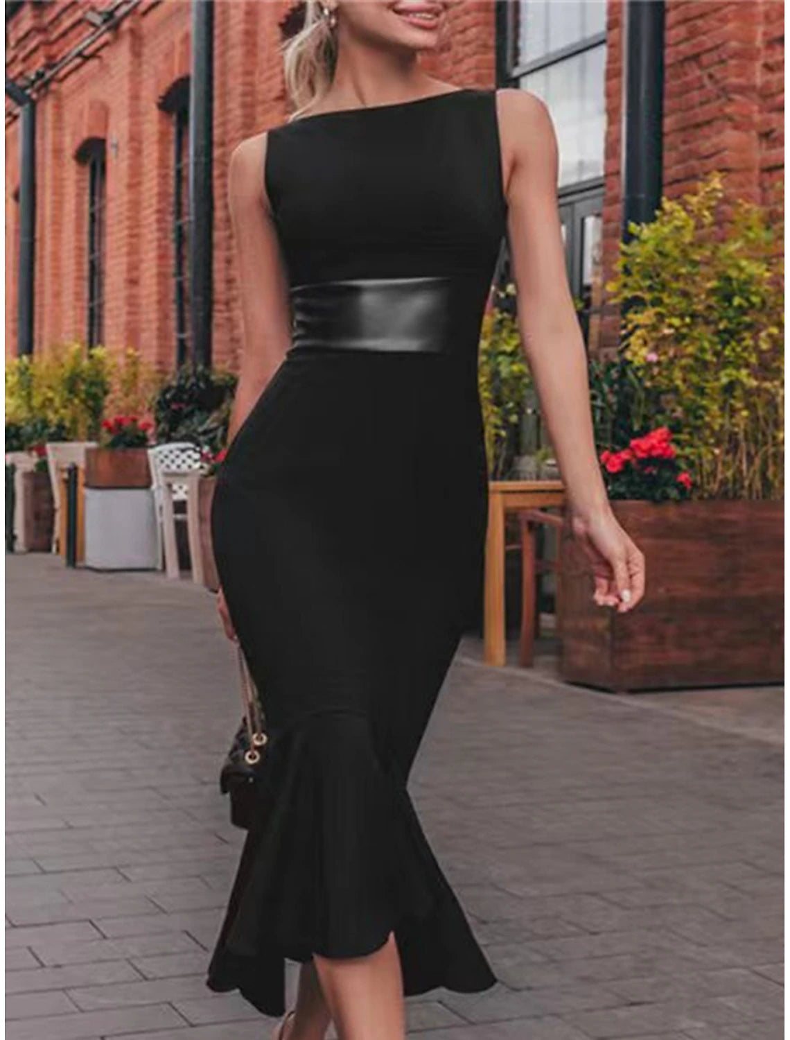 Woman wearing a black sleeveless crew neck midi dress.