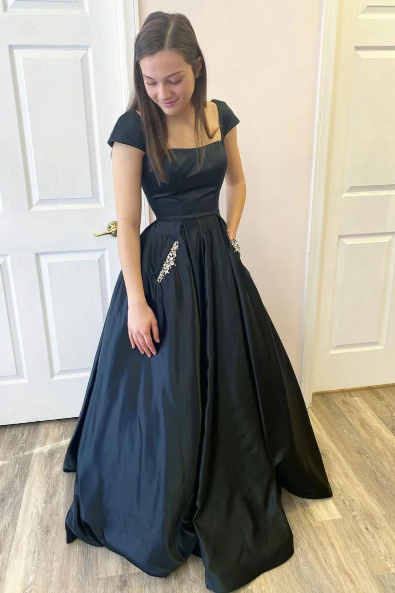 Model wearing an elegant black satin long prom dress with a backless design.