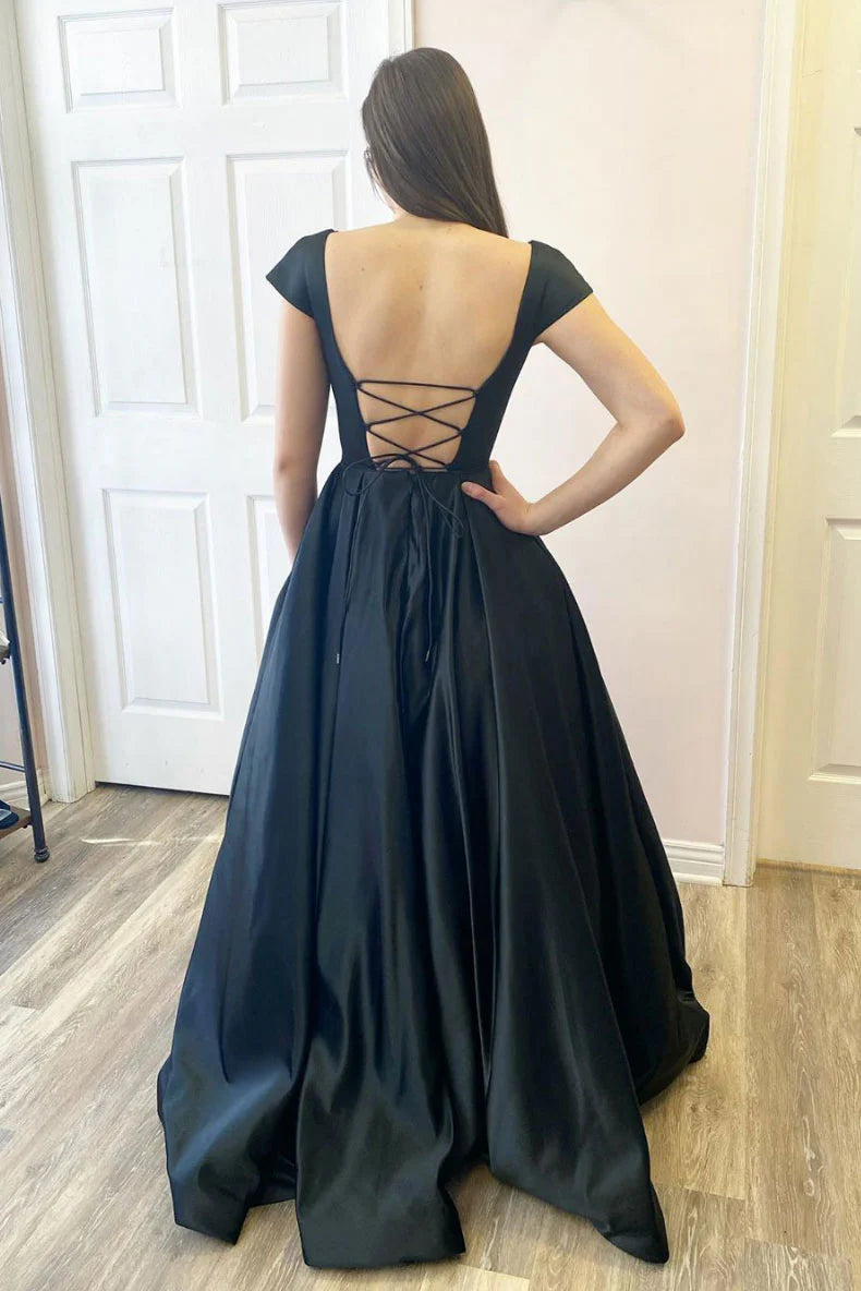 Back view of a model in a slim-fit black satin evening gown, highlighting the backless detail.