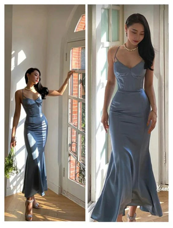 Woman posing in an elegant blue slim-fit mermaid evening gown.