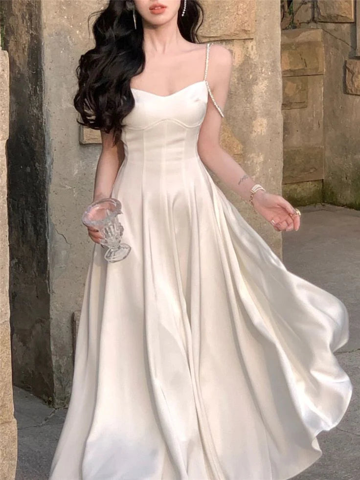 Woman wearing an elegant spaghetti strap midi dress, suitable for evening parties.