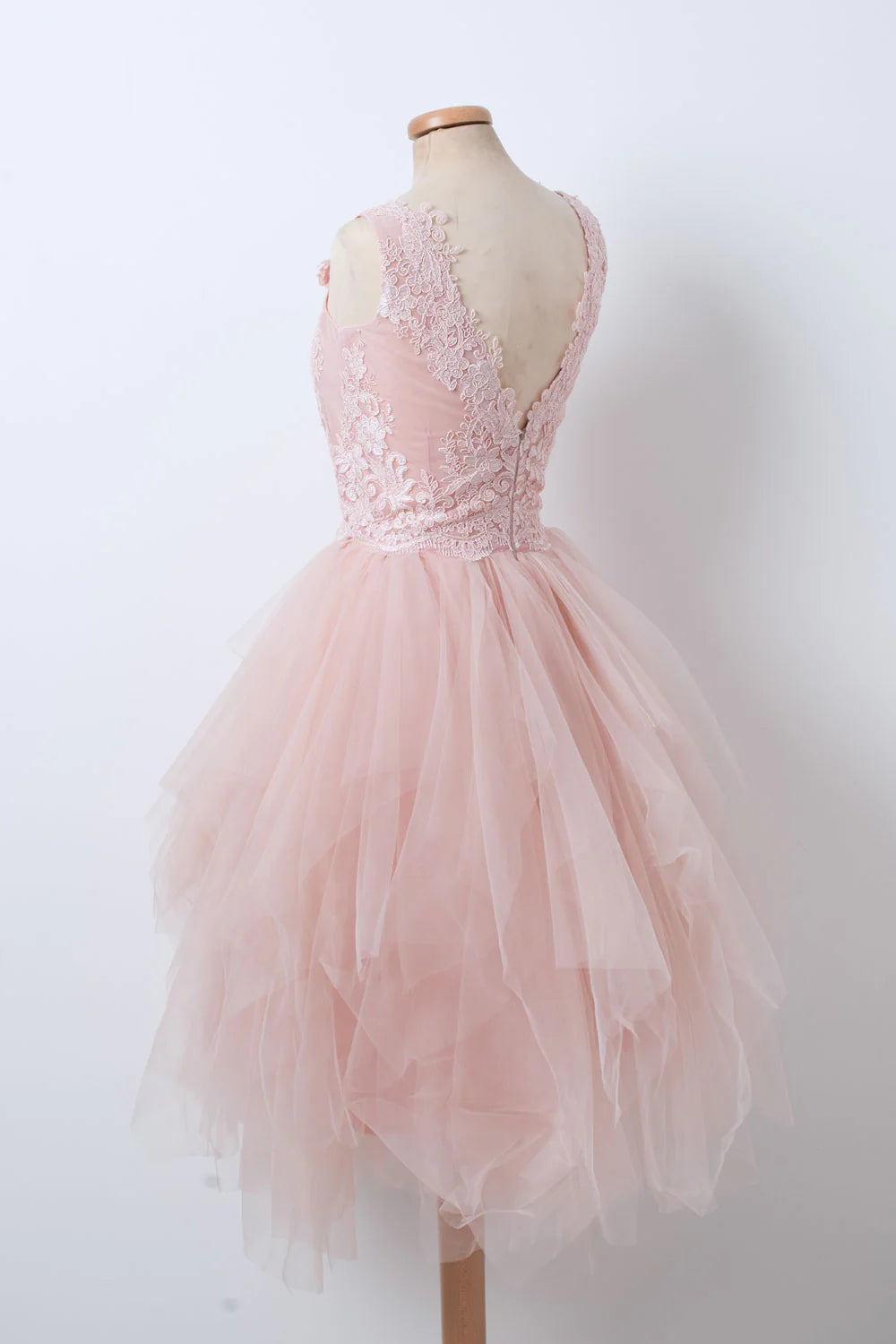 Side view of a woman wearing a pink V-neck tulle lace short homecoming dress.