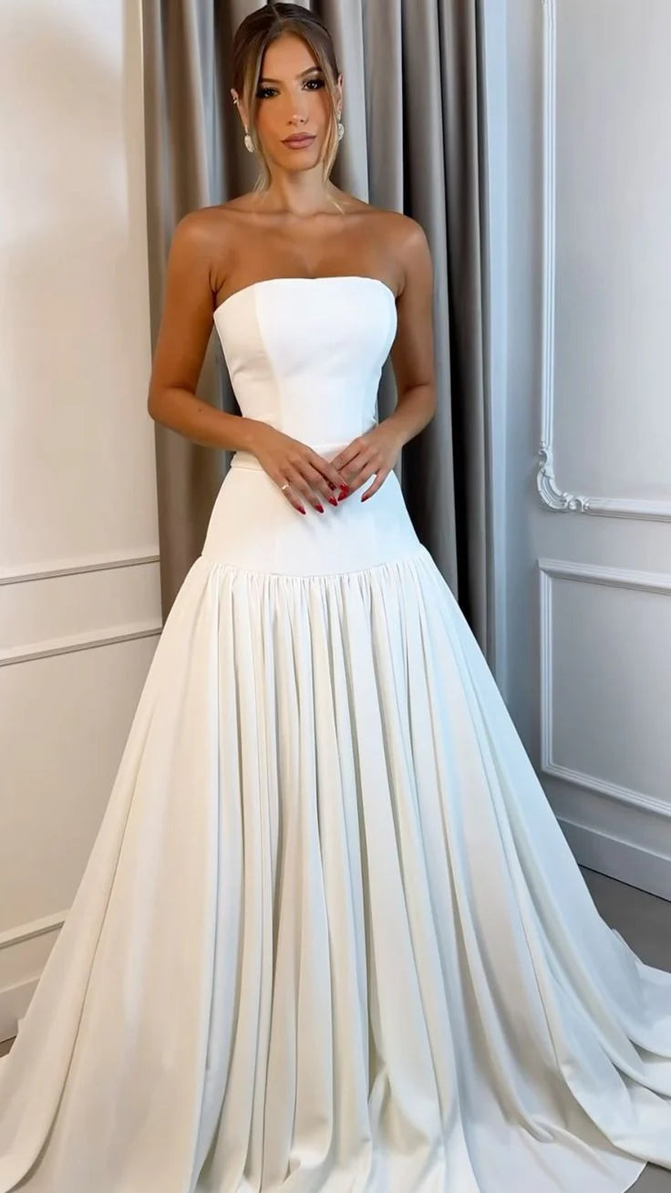 Woman wearing an elegant white strapless A-line satin wedding dress.