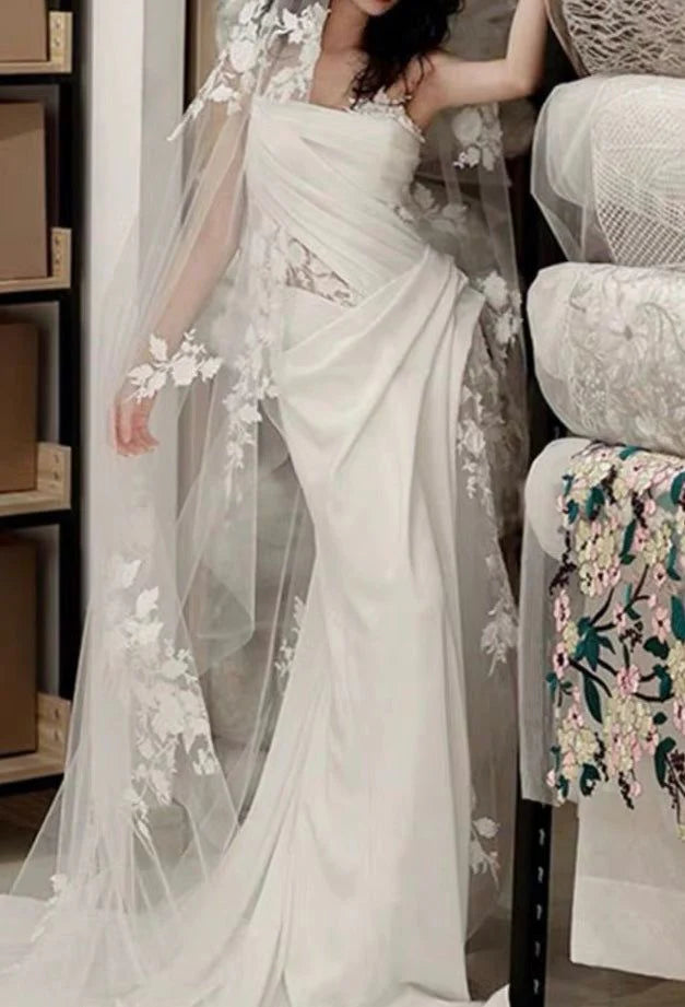 Full length view of a bride wearing a sophisticated pleated wedding dress.