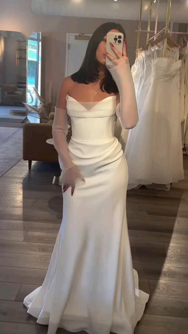 Elegant white strapless mermaid wedding dress with pleated satin fabric.