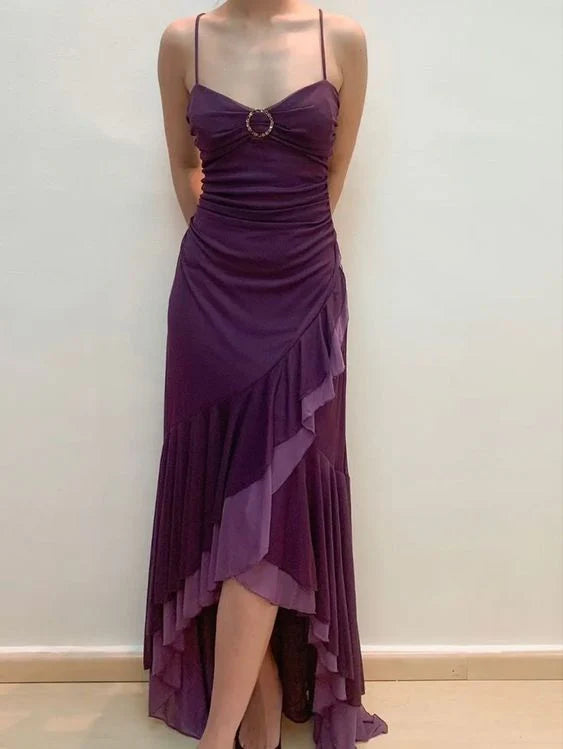 Model showcasing the back of a purple spaghetti strap prom dress.