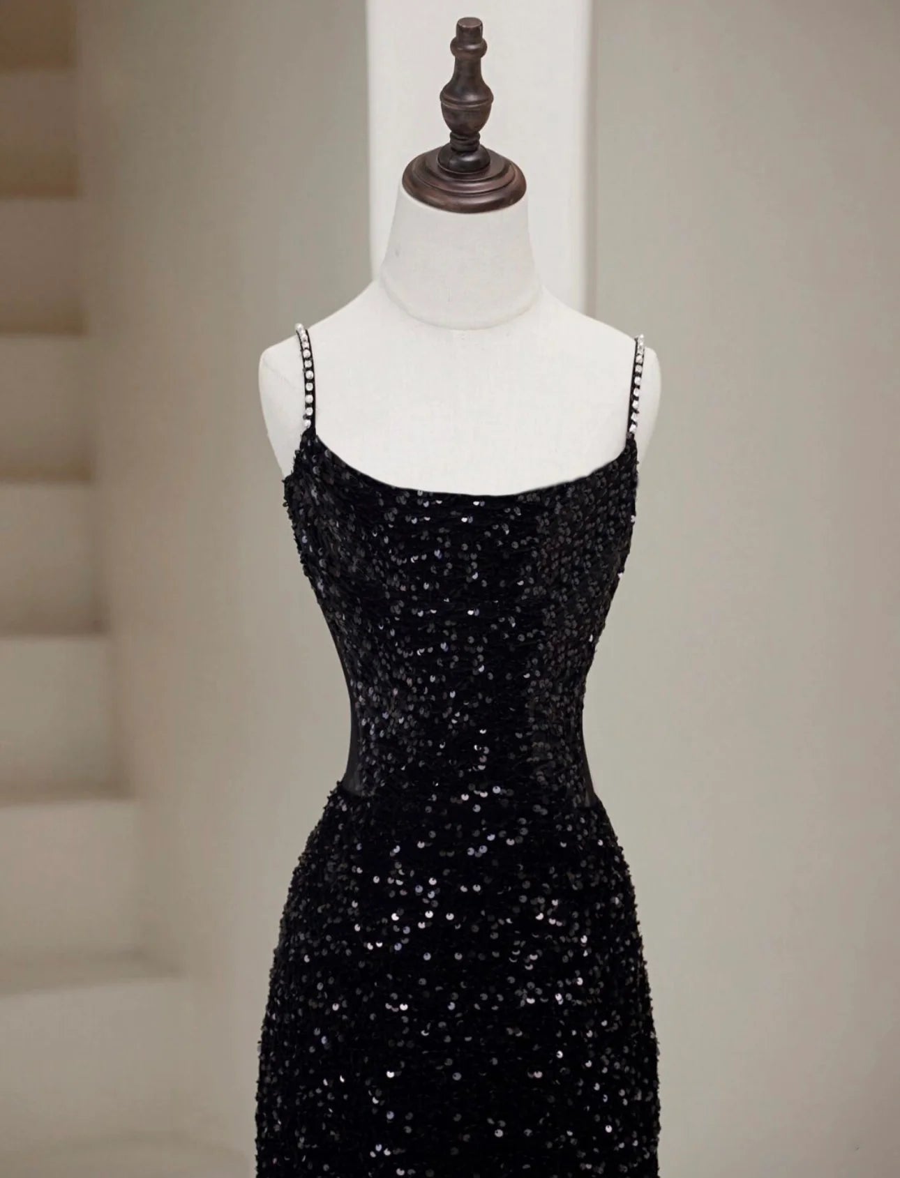 Back view of a black sequin mermaid long prom dress with a slight train.