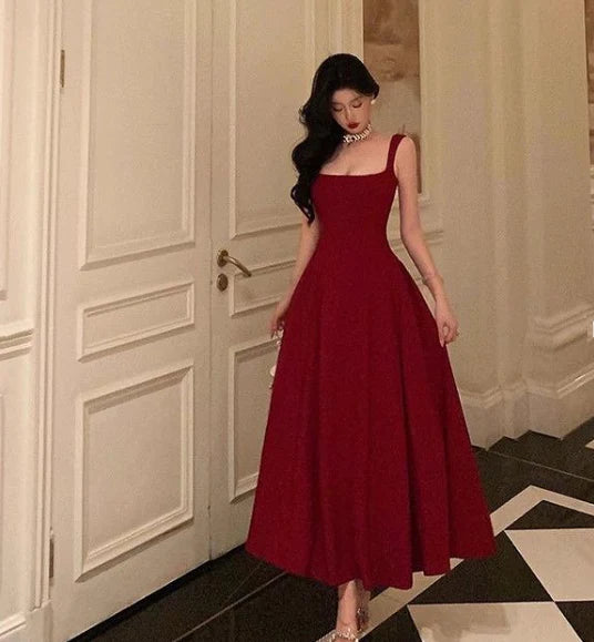 Side view of the flowing A-line skirt and burgundy fabric of the prom gown.