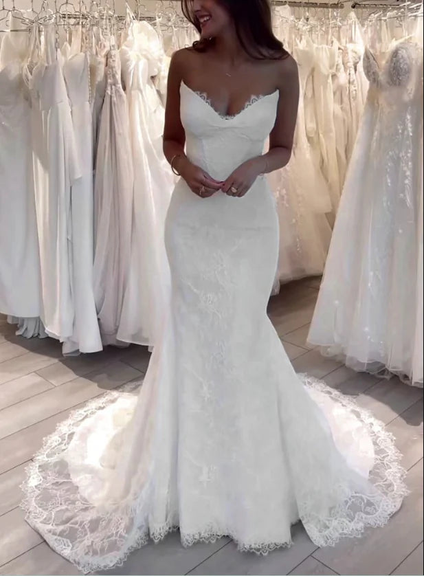 Model wearing an elegant white lace mermaid V-neck wedding dress.