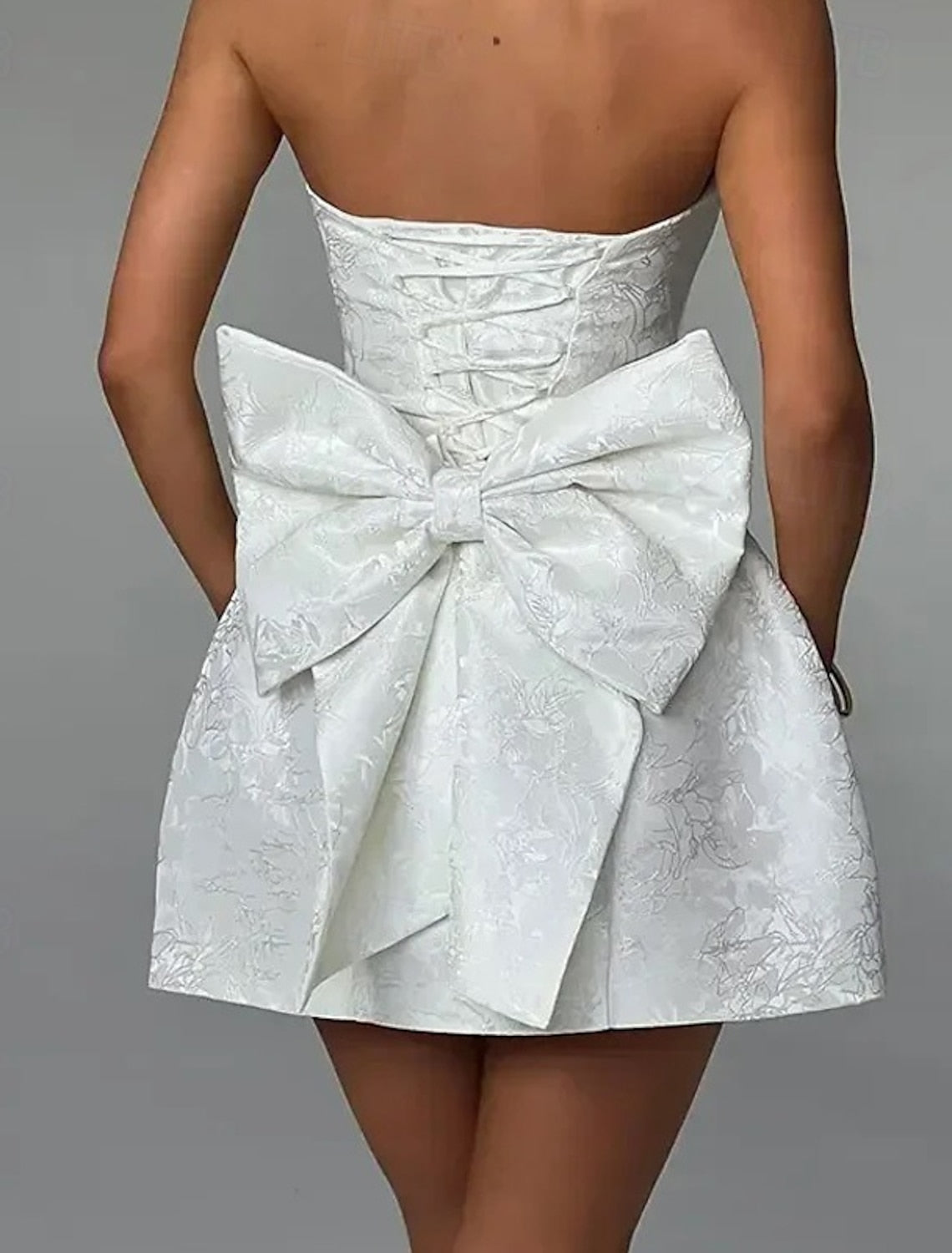 Solid color strapless sleeveless dress with a prominent bow tie detail.