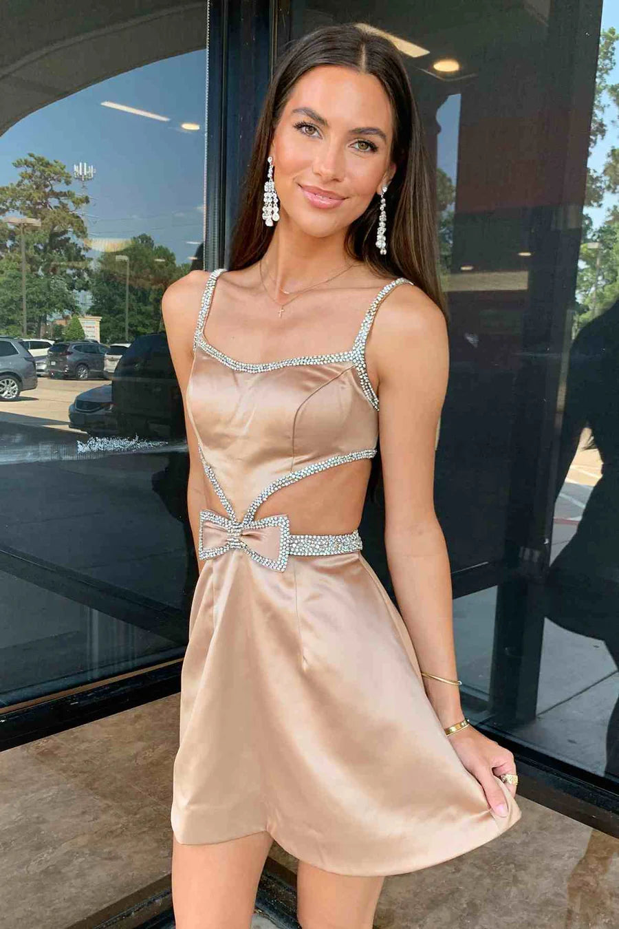 Front view of a blue cutout homecoming dress, showcasing spaghetti straps and a decorative bow.