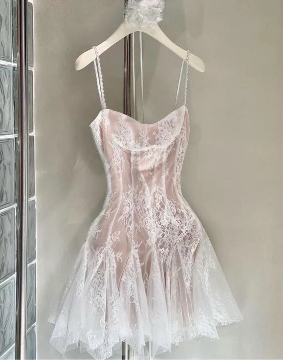 Woman wearing an elegant spaghetti strap mini lace cocktail dress, front view.