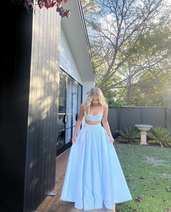 Model wearing a light blue two-piece formal evening gown with spaghetti straps.