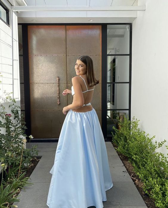 Full-length view of a model in a light blue spaghetti strap two-piece formal gown.