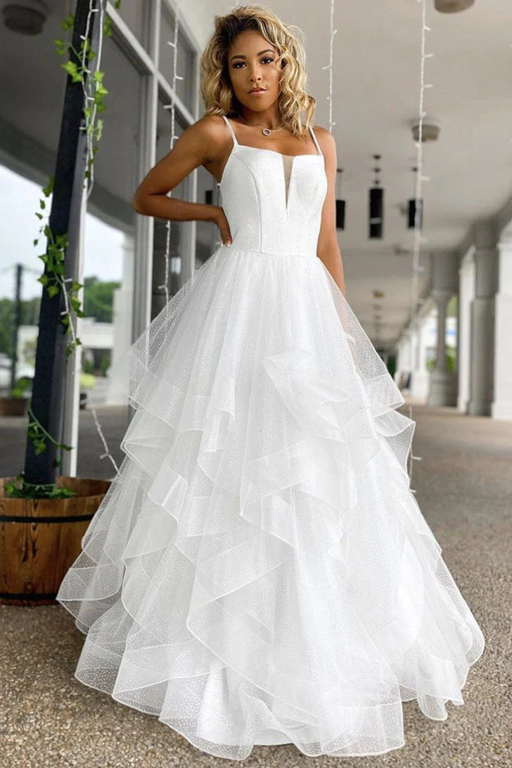 Elegant woman wearing a white off-shoulder long prom dress with sequin and tulle details.