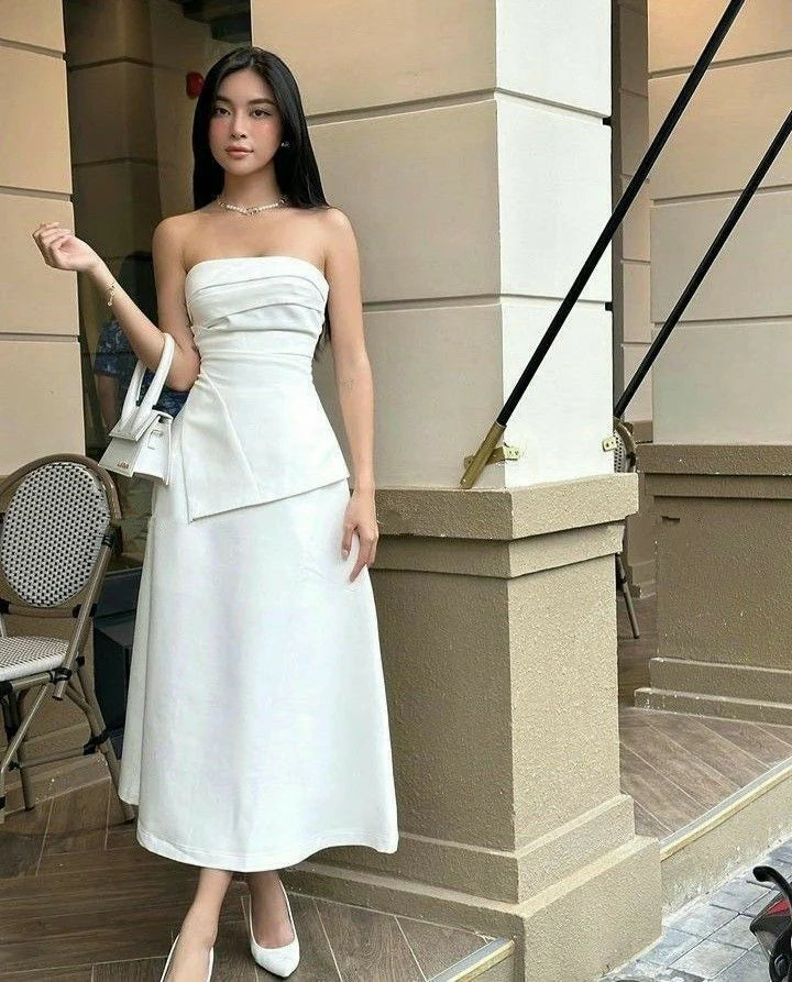 Woman wearing an elegant white strapless off-shoulder prom dress.