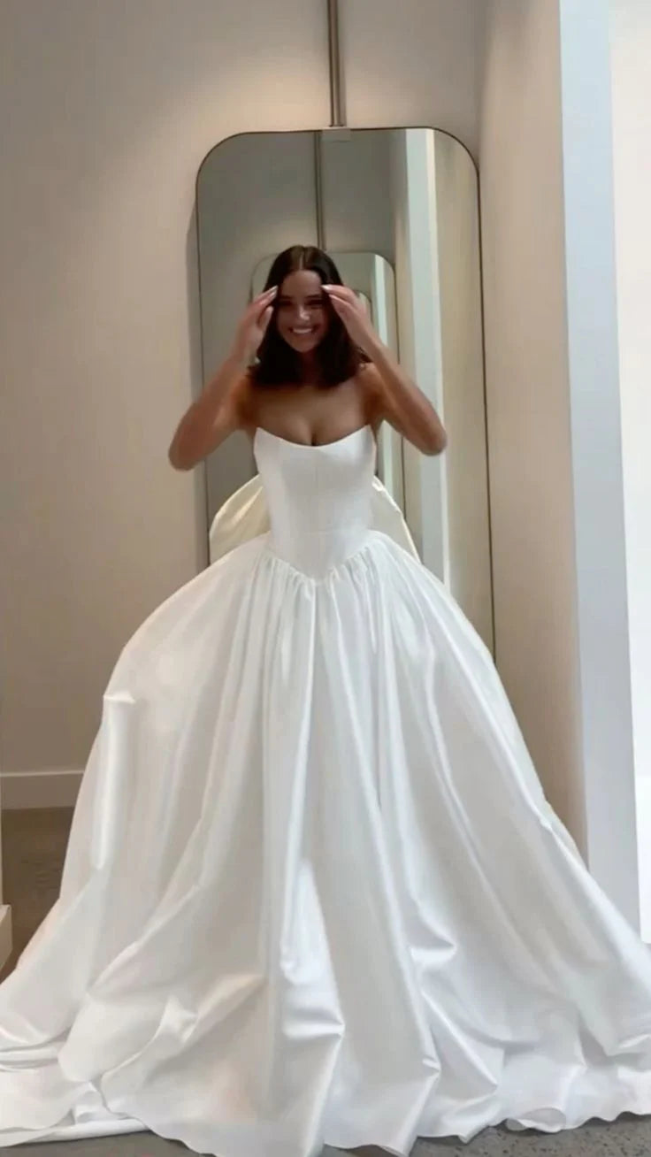 Model wearing an elegant strapless satin A-line wedding dress with a flattering cinched waist.