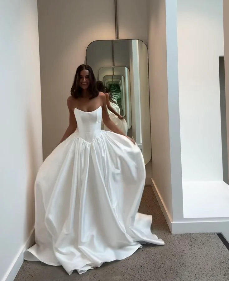 Close-up of the bodice and flowing skirt of the strapless satin bridal gown.