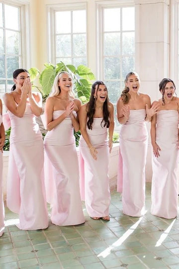 Front view of an elegant pink strapless scoop neck pleated satin long bridesmaid dress.