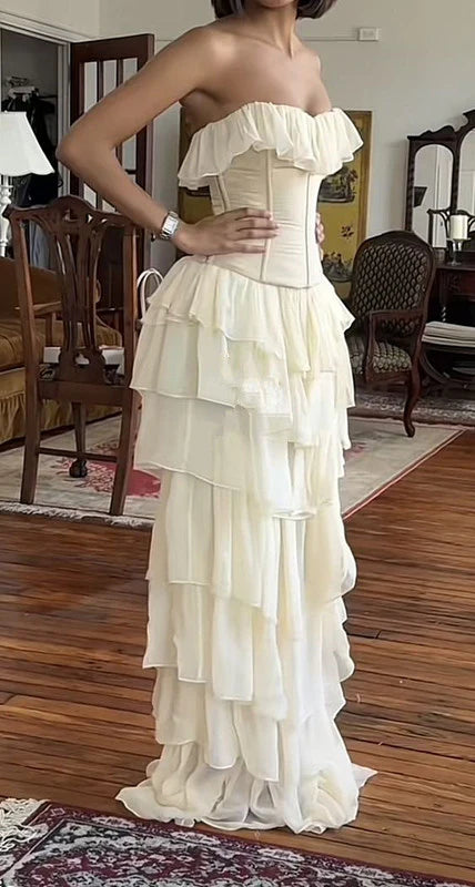 Elegant ivory strapless tiered chiffon evening dress on a model.