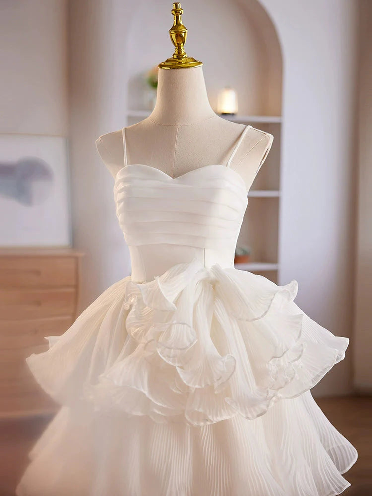 Close-up of the sweetheart neckline and organza fabric on a white short formal dress.