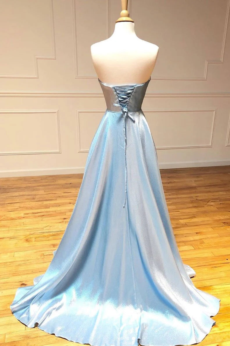 Side view of a woman in a blue off-shoulder evening gown with a flowing skirt.