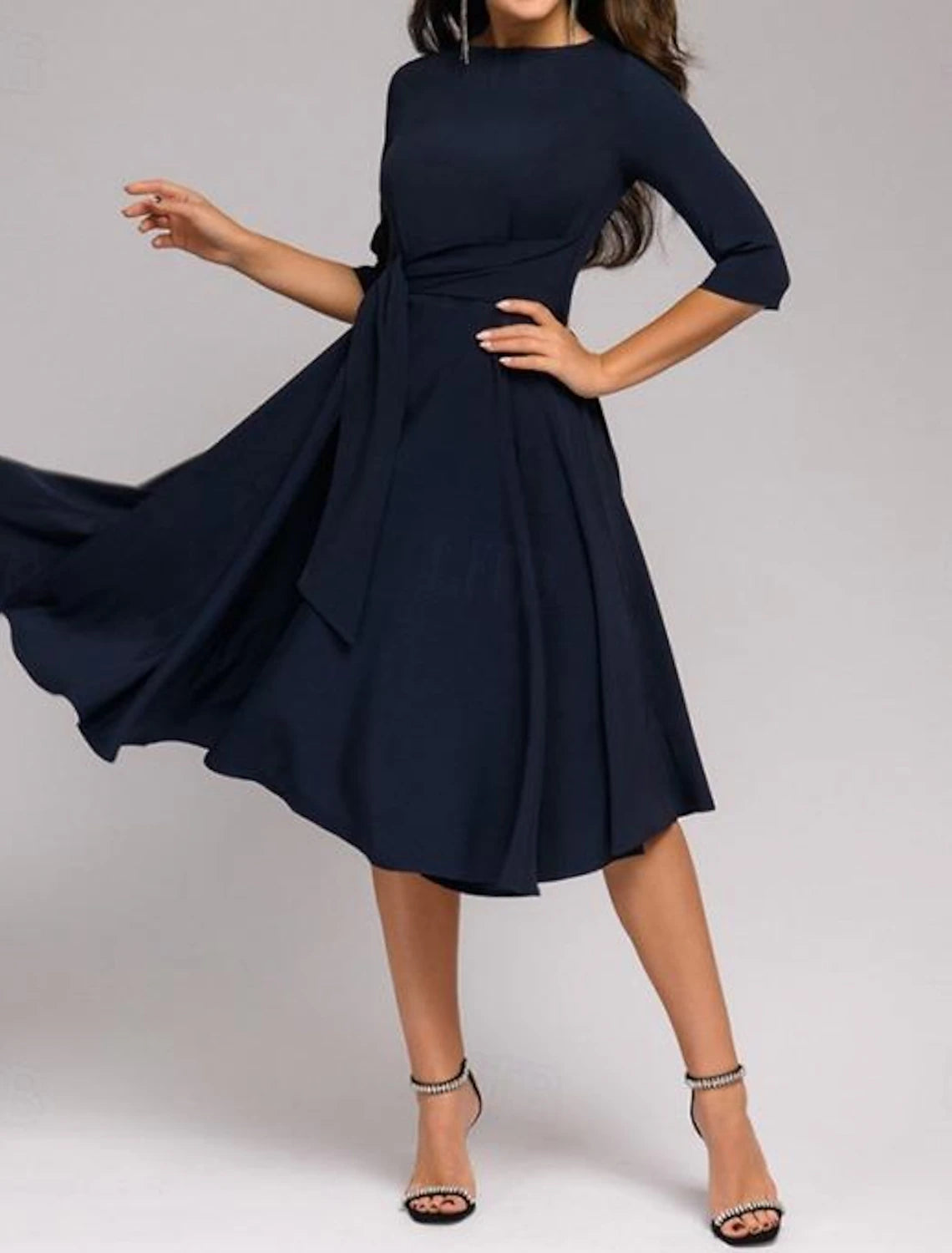 Woman wearing a tie-front belted midi dress with 3/4 sleeves and a crew neck.