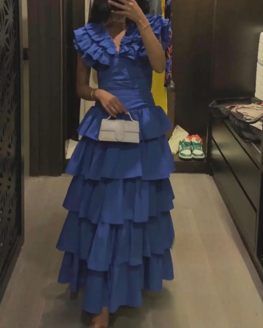 Woman wearing an elegant blue V-neck tiered evening gown.