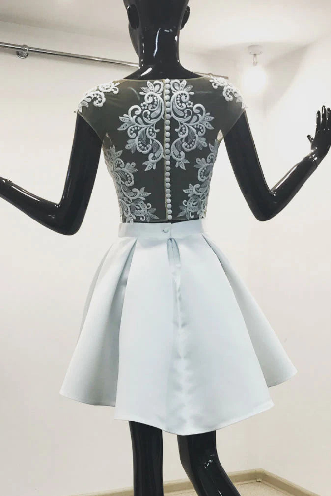 Model wearing a light blue two-piece lace short prom dress, side view.