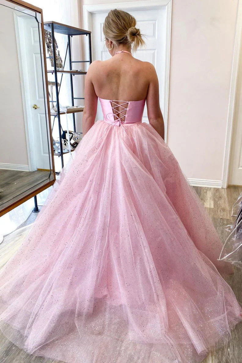 Model posing in a pink two-piece satin long prom dress with a waist cutout.
