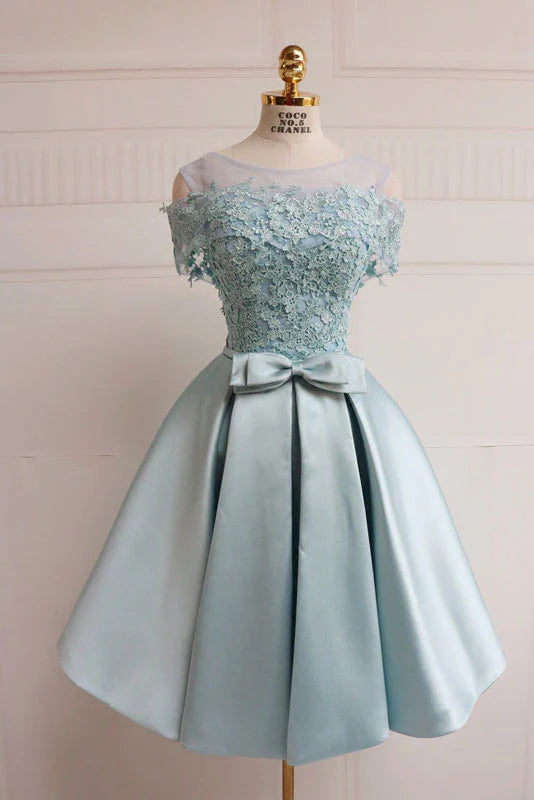 Model wearing an elegant blue lace short prom dress with a V-neck and cinched waist.