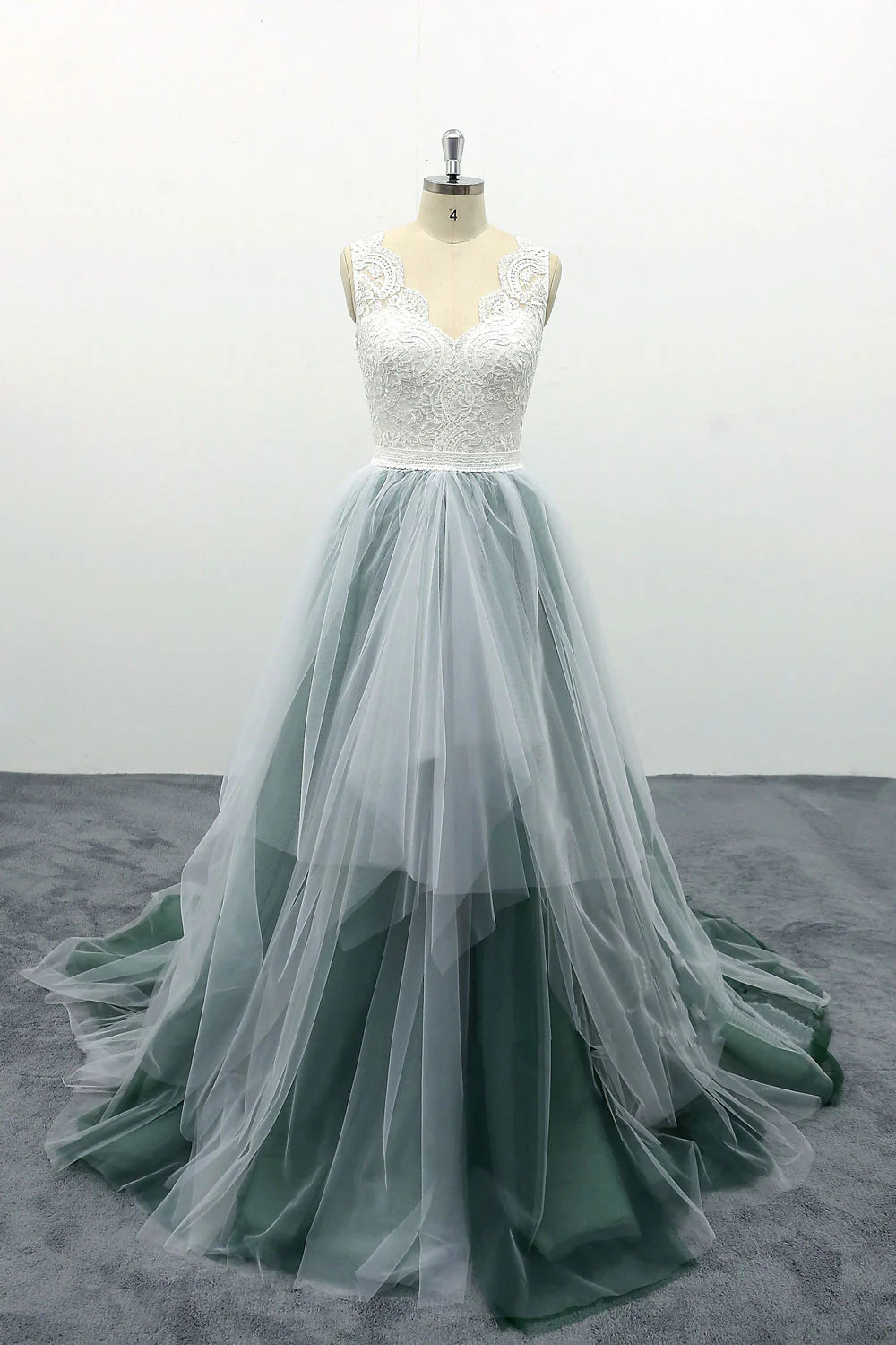 Elegant green V-neck A-line prom dress with lace bodice and flowing tulle skirt.