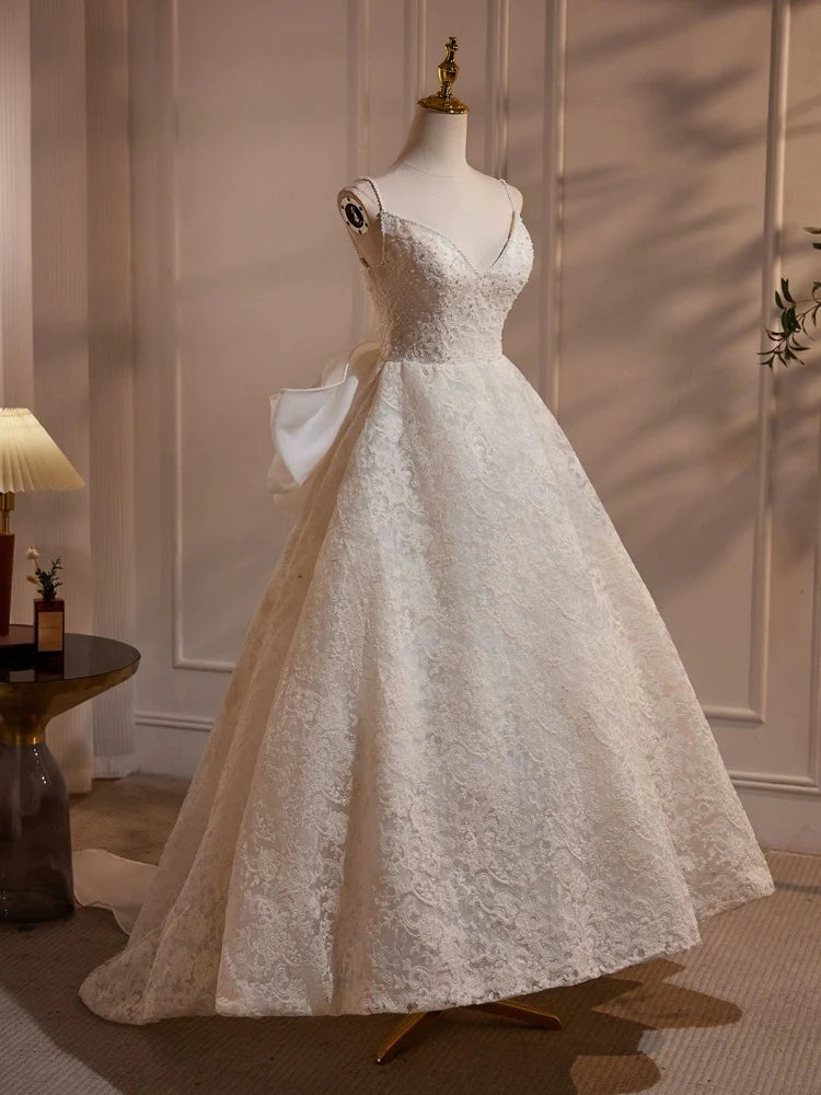 Woman wearing an elegant light champagne lace long dress for prom or wedding.
