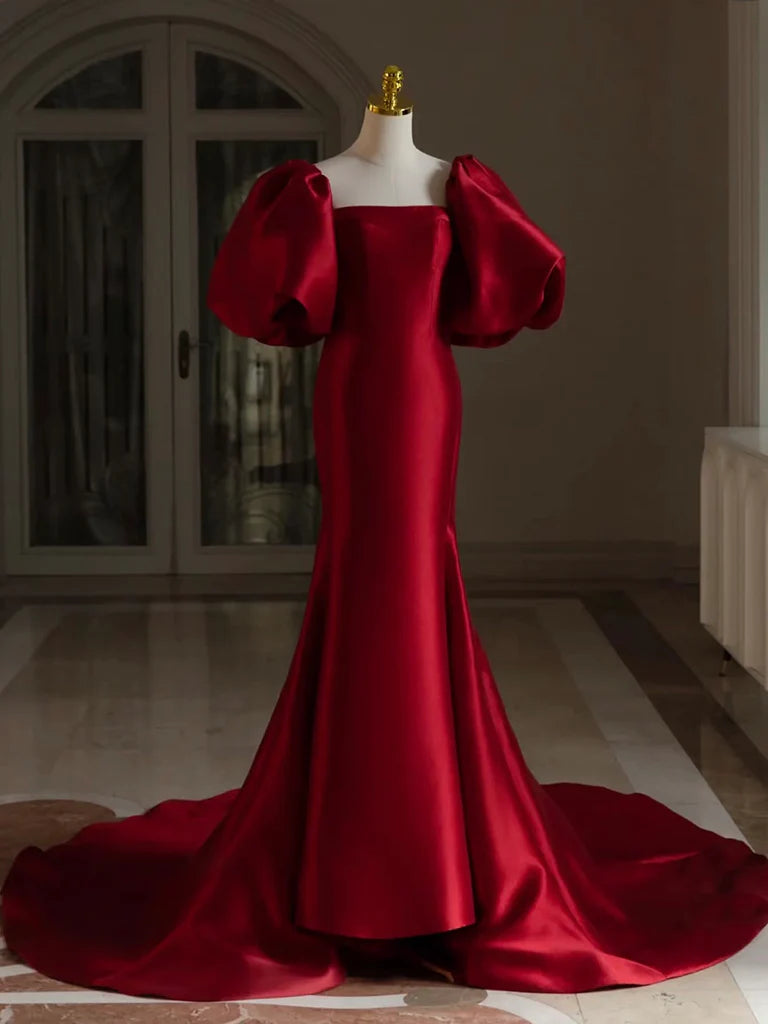 Model wearing a long burgundy satin prom dress with puff sleeves and V-neck.
