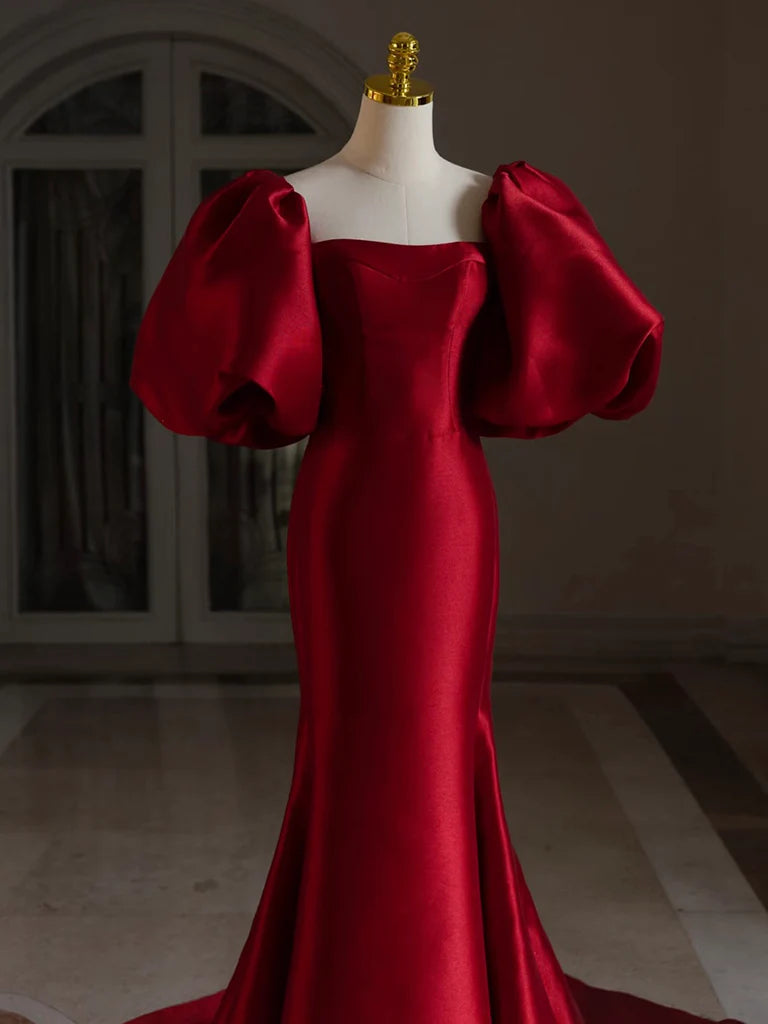 Close-up of the puff sleeves and satin fabric on the burgundy dress.