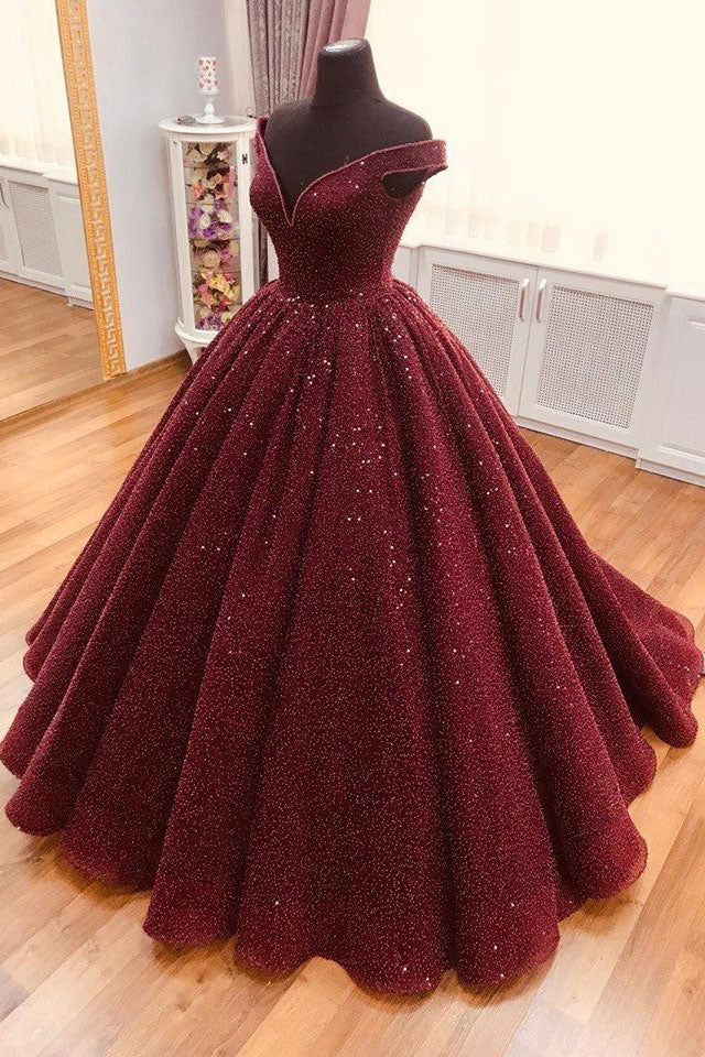 Woman wearing an elegant burgundy V-neck long prom dress.