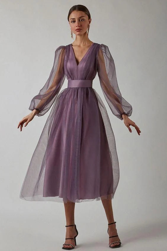 Full-length view of a woman in a graceful long formal dress with a V-neck.