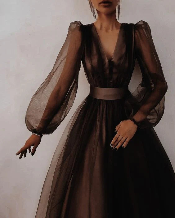 A woman in a long, simple V-neck evening dress, viewed from the side.