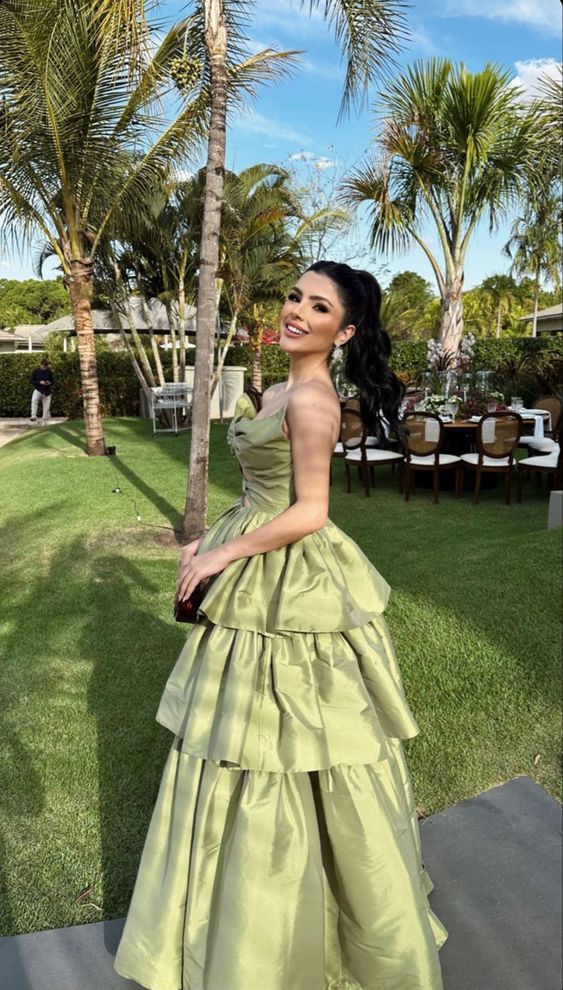 Side view of a woman in a sage green A-line satin V-neck formal dress.
