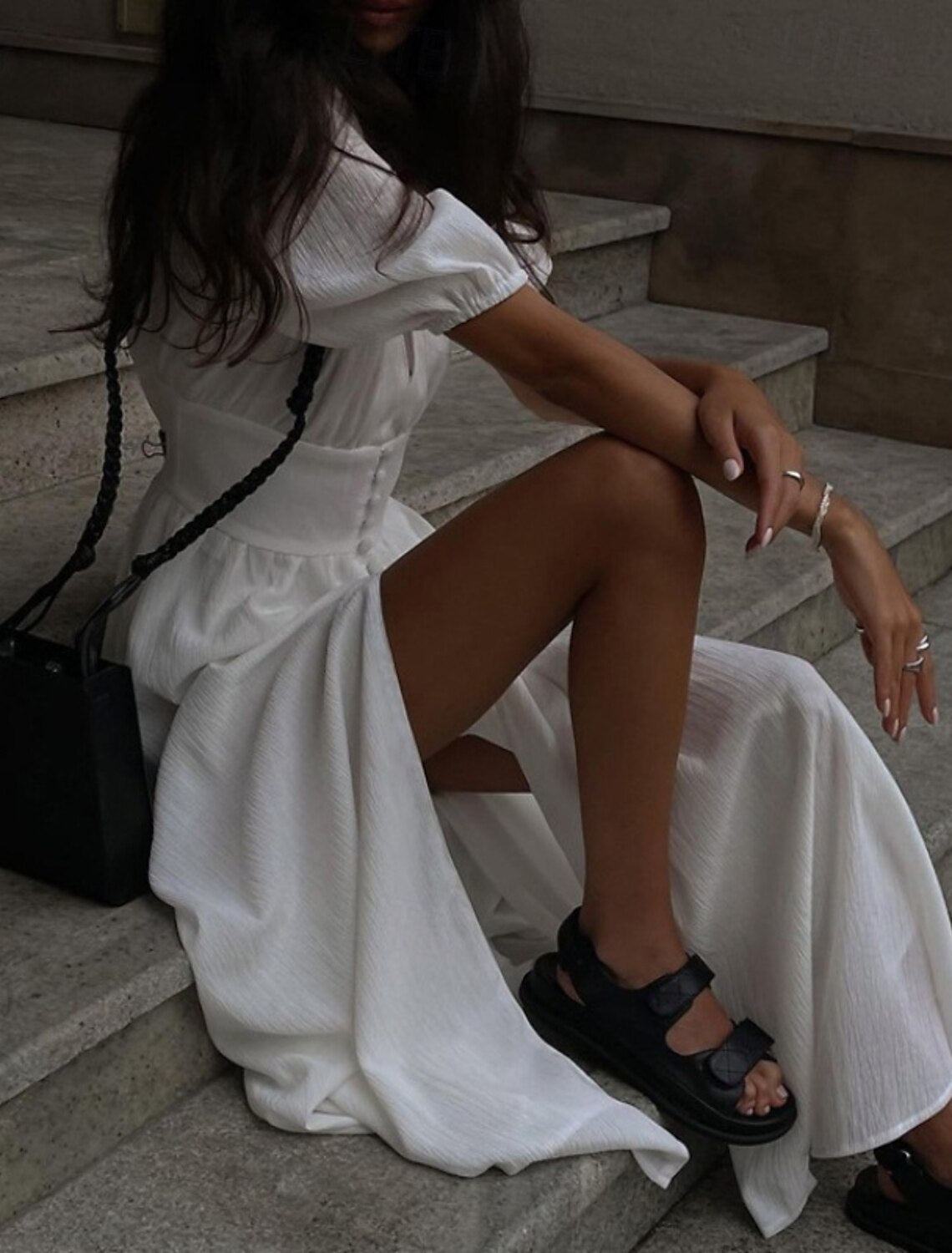Back view of a woman wearing a modern white party dress.