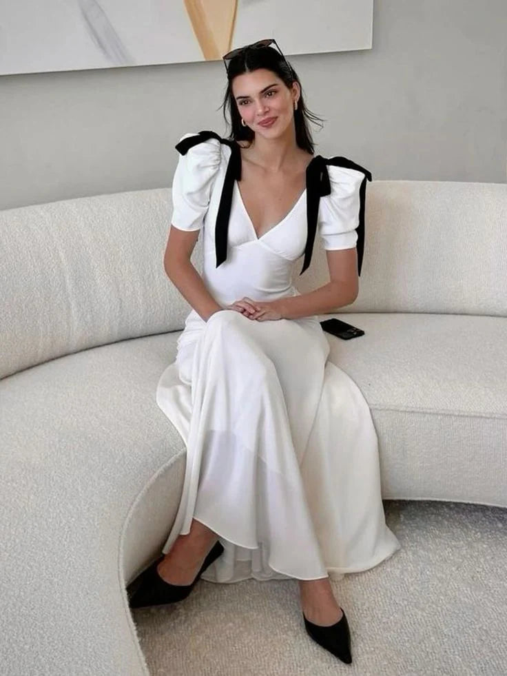 Woman wearing an elegant dark V-neck puff sleeve maxi dress.