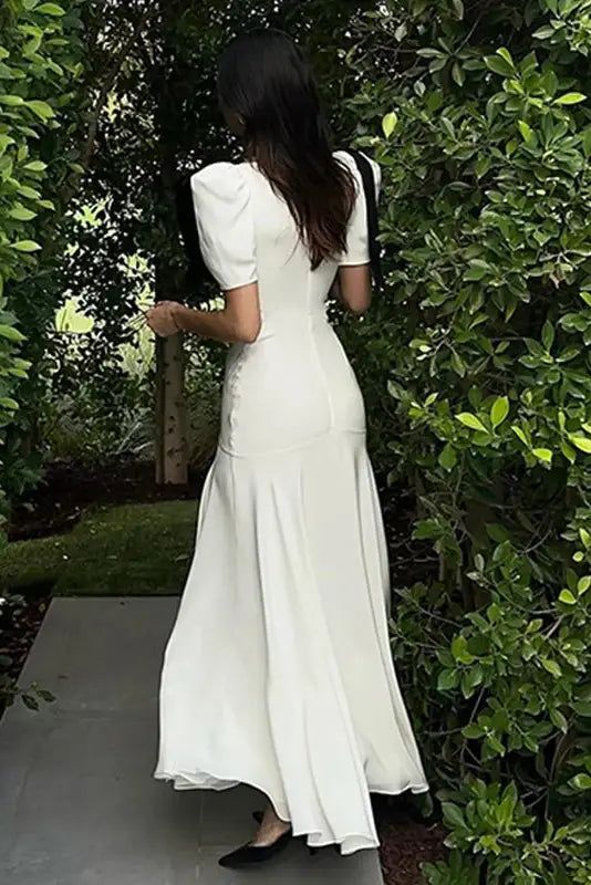 Back view of the elegant dark maxi dress with puff sleeves.