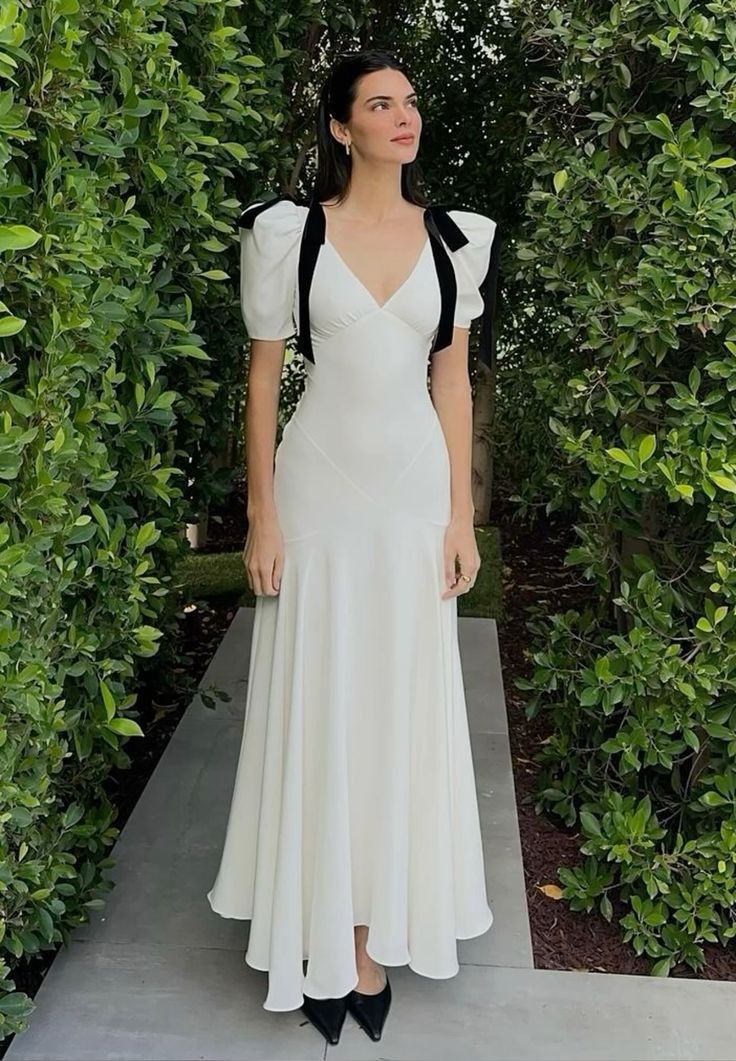 Full length view of a woman posing in the dark elegant evening dress.